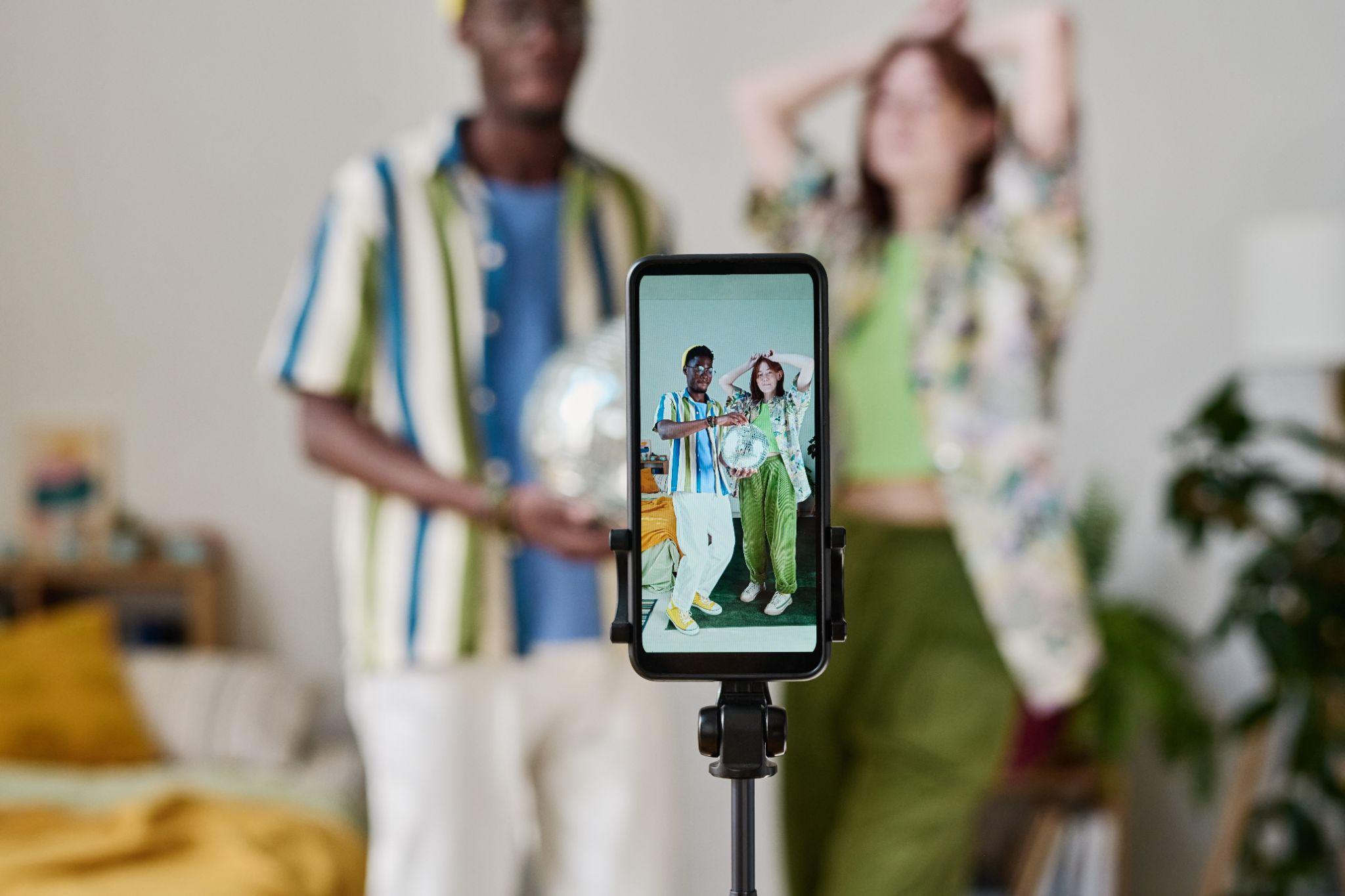 Deux influenceurs présentent des produits, ils collaborent sur de la création de contenu grâce à un smartphone et un trépied. 