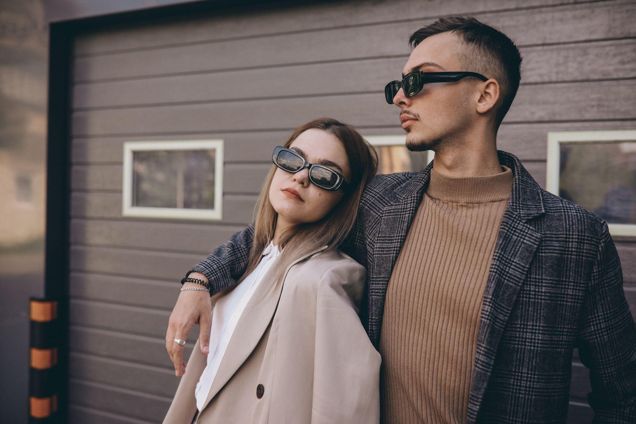 Deux modèles posent pour présenter des vêtements de qualité dans un lookbook. Ils portent des vêtement chics, des lunettes de soleil et des bijoux.