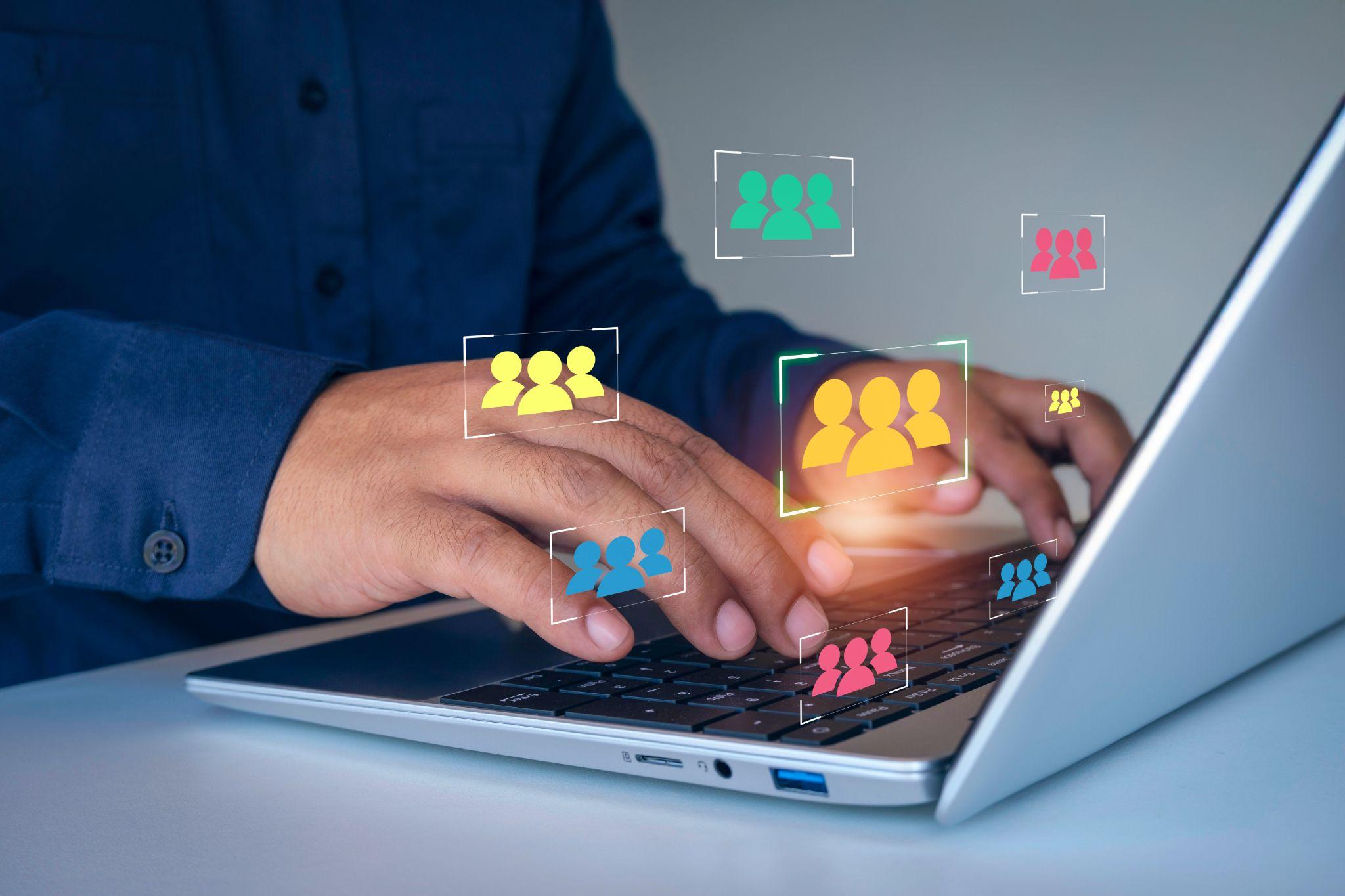 Mani sulla tastiera di un computer con icone di gruppo e personas - definizione del cliente target per una boutique di moda (marketing B2B).