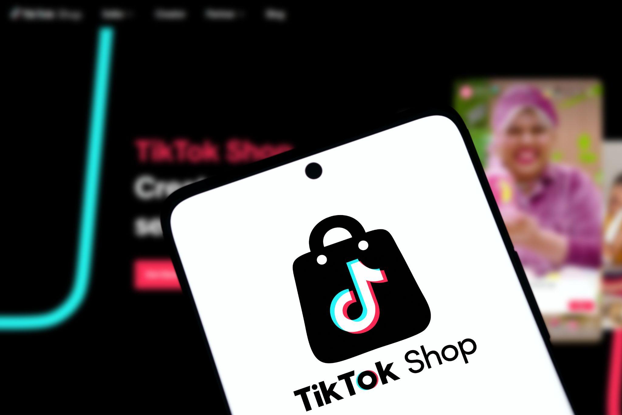 Smartphone affichant le logo de TikTok Shop — animation des réseaux sociaux pour une boutique de mode.